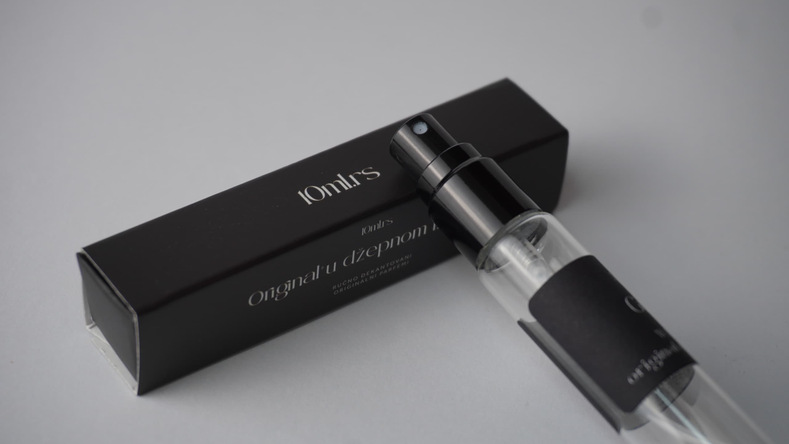 A 10 ml decant leaning on a black 10ml.rs box